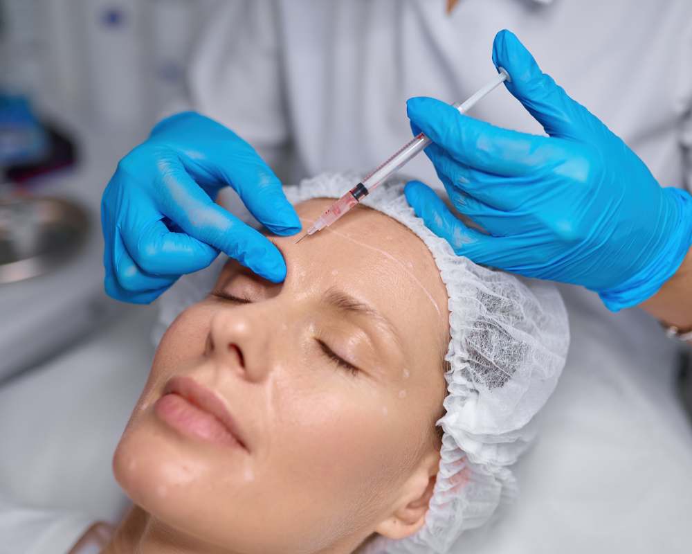 donna over 50 che sta ricevendo un trattamento di botox sulla fronte